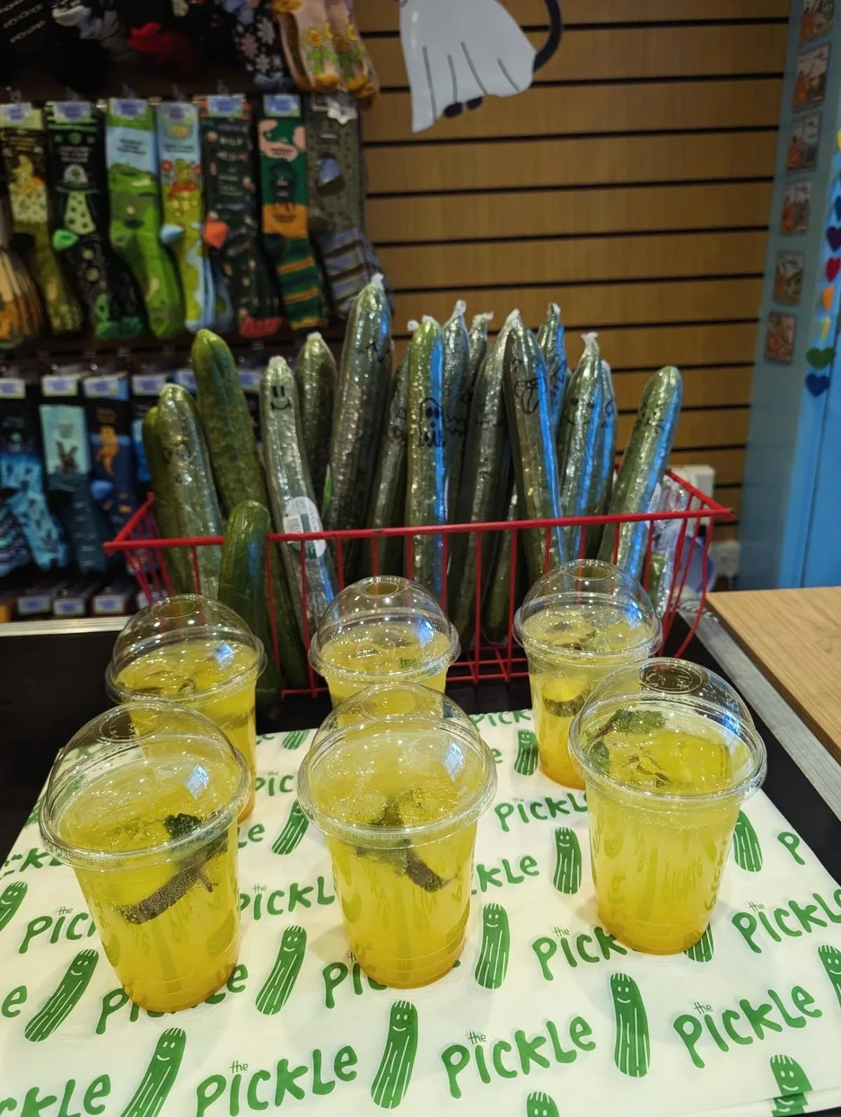 Cups of pickle lemonade on pickle-print paper at The Pickle Brighton